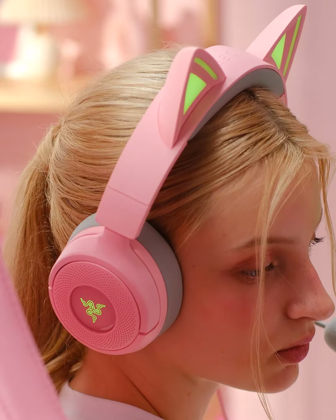 Fată purtând căștile roz Razer Kraken Kitty V3 cu urechi iluminate